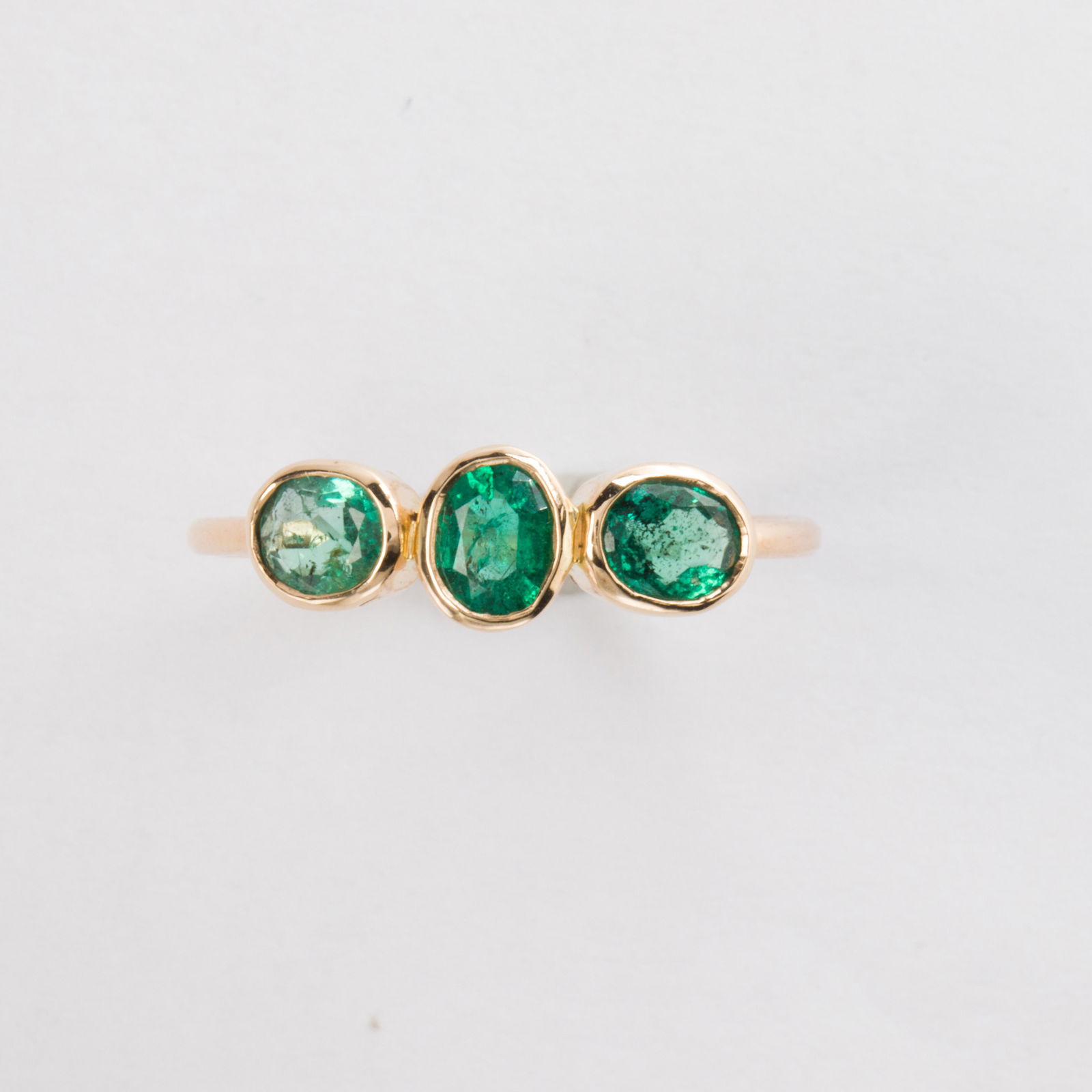 A pair of emerald and fourteen karat gold stacking ring: A pair of emerald and fourteen karat gold stacking ringdesigned as oval or square-shaped emeralds, bezel-set on polished gold hoops. 2.3 dwt; Sizes: 8 1/4, 8 1/4