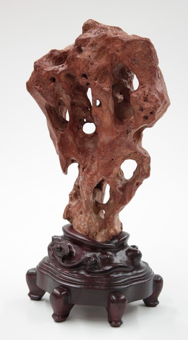 Chinese Scholar's Rock (Gongshi): Chinese Taihu scholar's rock (gongshi), with the typical fantastic configuration suggestive of a the stone of Lake Tai, rising and curving around several large holes, the coral colored matrix of mottl