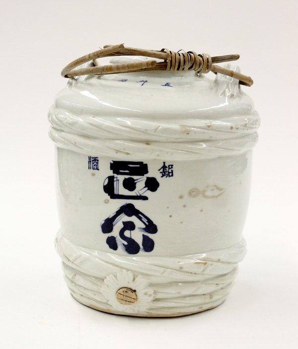 Japanese Ceremonial Porcelain Sake Cask: Japanese white porcelain sake cask, molded in the shape of a wooden sake cask bound with straw rope, the front with the name of the maker in underglaze blue, with a bamboo handle, 12.25''h