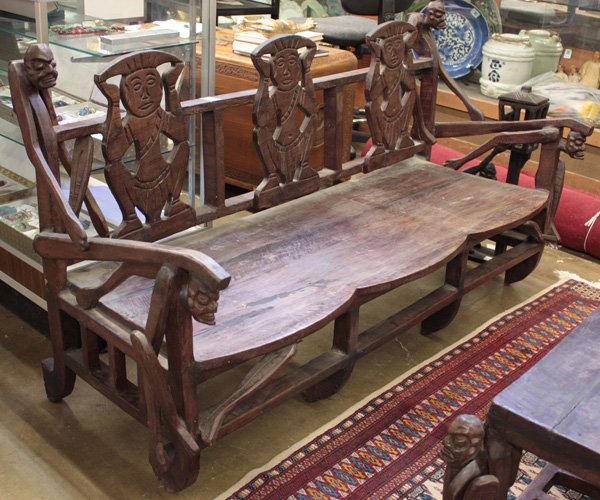 African Carved Hardwood Settee: African hardwood settee, with the back splat carved with three figural plaques flanked by stylized figures at either end and supporting the side arms, 61''l