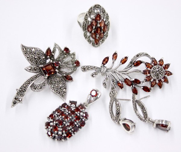sterling silver, garnet and marcasite jewelry: Collection of sterling silver, garnet and marcasite jewelry, including; one brooch, one ring, pair of earrings and brooches.