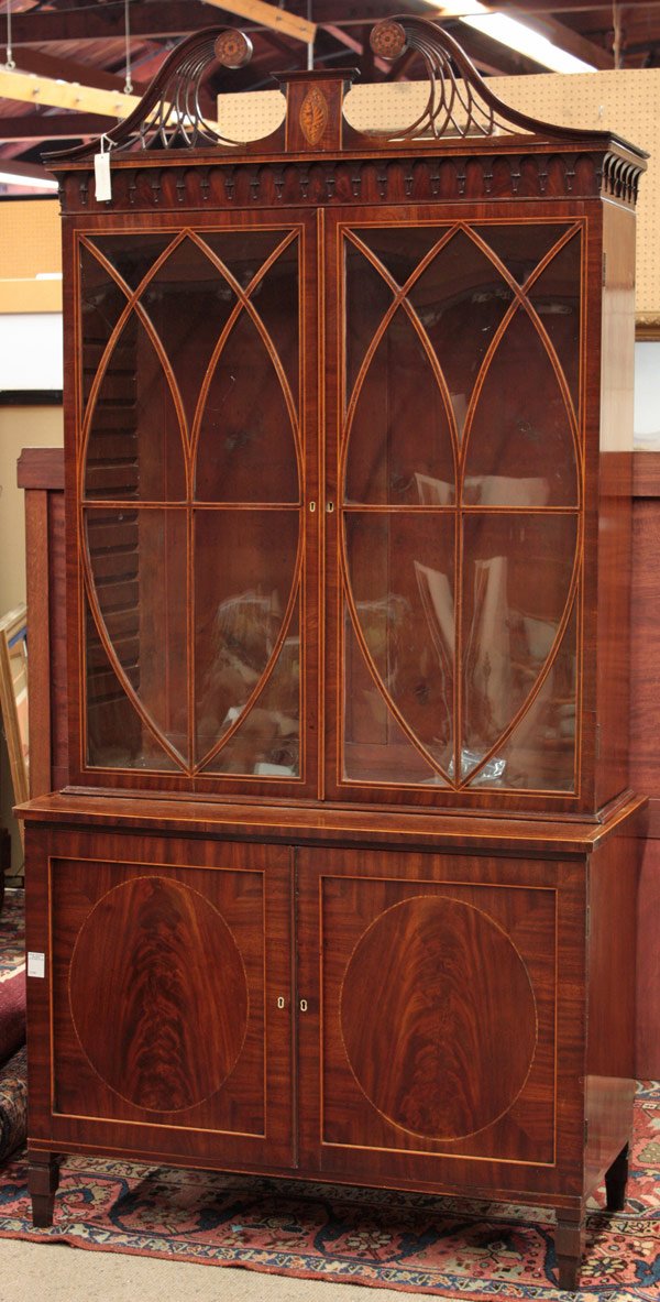 Late Georgian flame mahogany secretary: Late Georgian flame mahogany secretary in two parts having fretwork cornice with inlaid rosettes centered with conch shell patera, elliptical mullioned glass doors over stepped double door base with c