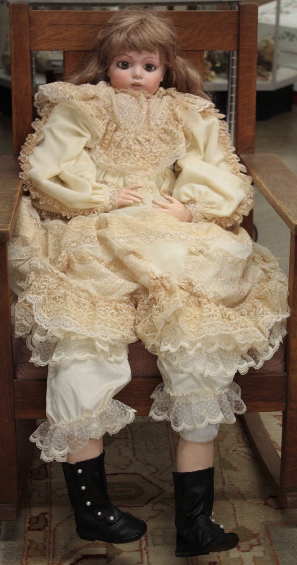 Vintage dolls: French bisque socket head doll having hand decorated facial features, hazel paperweight eyes, and an open mouth showing four teeth, on a cloth body with composition limbs, appropriately dressed, marke