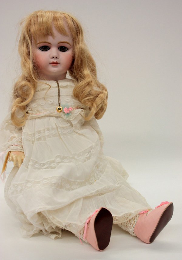Vintage dolls: Donna Frame bisque socket head doll having molded and hand decorated facial features, fixed hazel papwerweight eyes, and a closed mouth, on a jointed composition body appropriately dressed, marked DEP