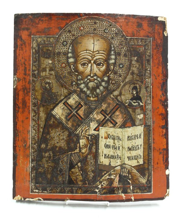 Russian icon: Late 18th to early 19th century Russian icon in polychromatic and silver gilt decoration depicting St Nicholas, 16''h x 13.5''w, cupped and has some worm damage. Denver Art Museum Deaccession
