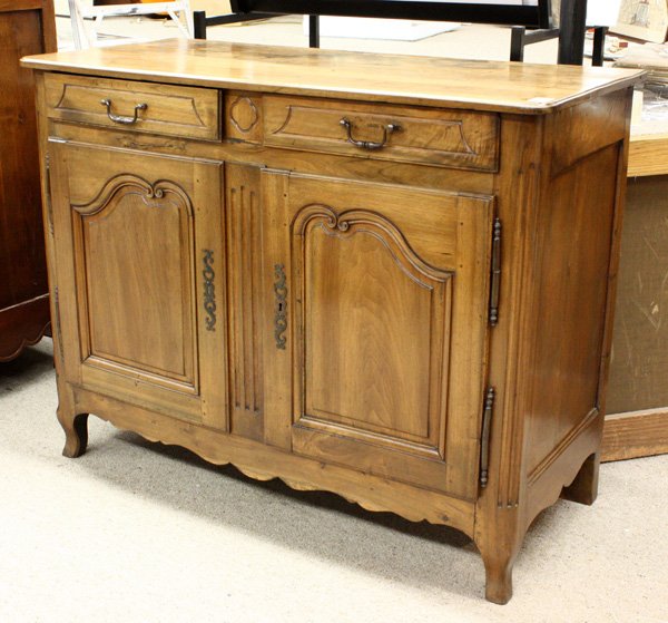 Louis XV style walnut buffet: Louis XV style walnut buffet, early 19th century, having shaped and panelled double doors embellished with scrollwork, fluted and rounded corners, and pierced, stylized escutcheons, 41''h x 52''w x 24