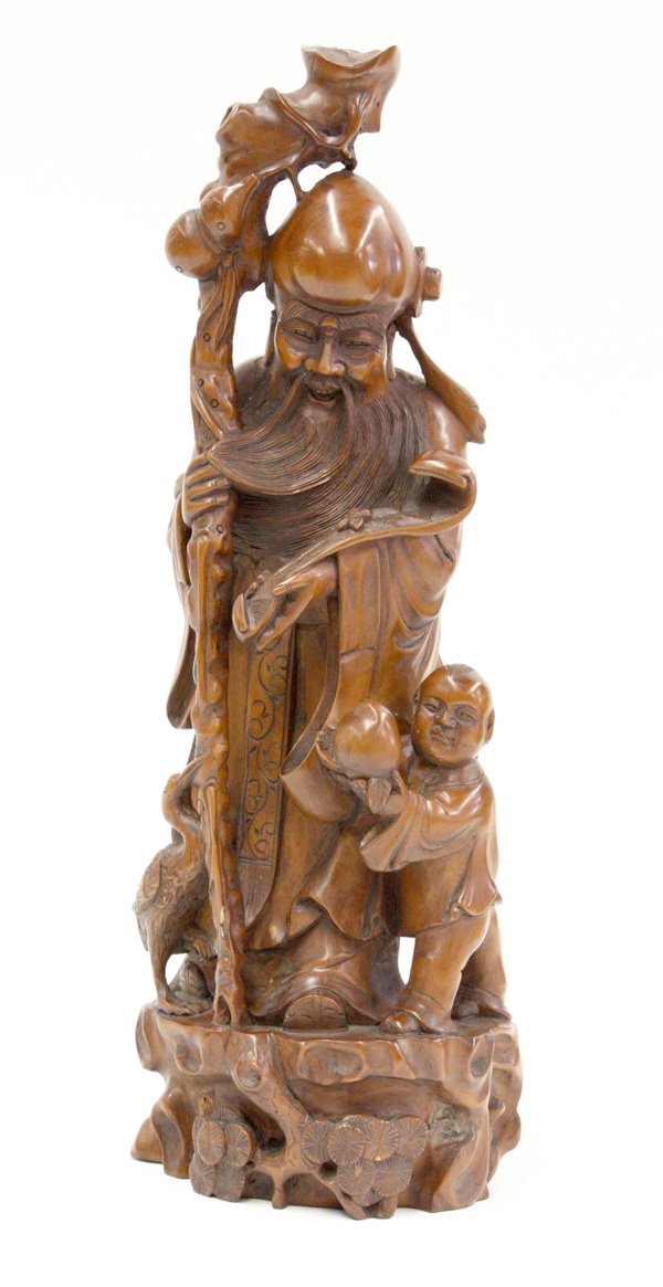 Chinese Boxwood Shoulao: Chinese boxwood carving of Shoulao, the deity of longevity holds a long staff stroking his beard and with a scepter to the other arm, flanked by a child with a peach and a small crane supported on roc