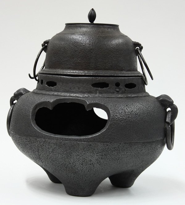 Japanese Tea Ceremony Kettle and Braizer: Japanese tea ceremony iron brazier and kettle, of traditional compressed ovoid shape resting on three supports and with a pair of mask and loose ring handles, the pierced collar set with a separately 