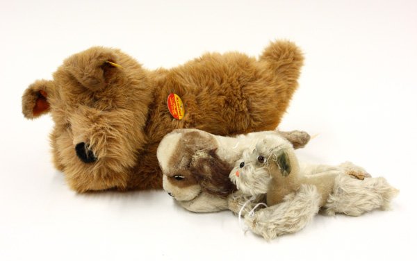Steiff dogs: (lot of 3) Steiff dogs, ''Kuschel Hund 30'' with glass eyes and yellow ribbon, brass tag in ear and having Steiff labels, 12'' l; together with a spaniel having Steiff silver colored tag in ear, 7''l;