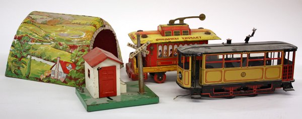 Trains: (lot of 4) Metal toys, ''Broadway Trolley 10430'', a trolley with both electric and wind up power possibilities, a tunnel having landscape scenes, a railroad crossing hut with swinging door and railro