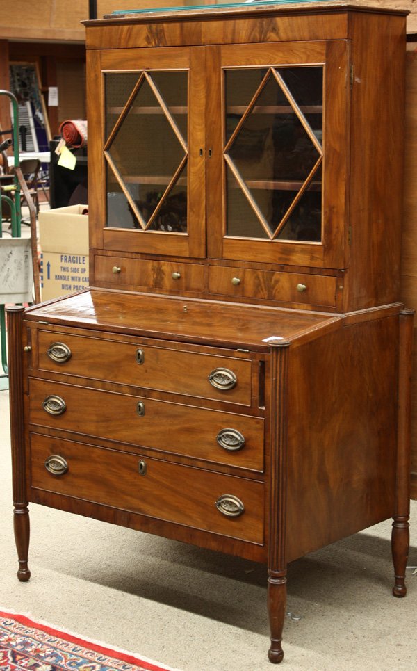 American Sheraton Secretary, Flame Mahogany: American Sheraton two-part secretary in flame mahogany with a flat cornice over diamond mullioned doors, a fold-out slanted writing surface, flanked with ovolu corners, and having cock beaded drawers,