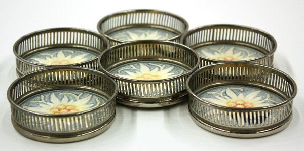 German faience coasters: (lot of 6) German faience coasters having stylized floral motifs mounted by a silverplate reticulated gallery, .75''h x 3''diameter