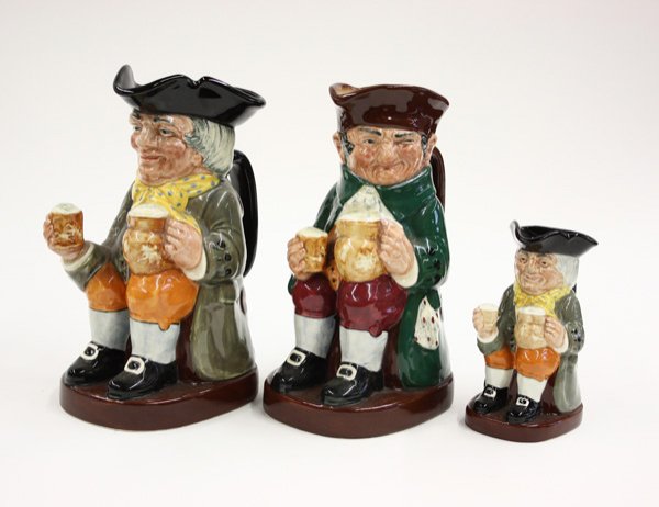 Royal Doulton, Toby jugs: (lot of 3) Two large Royal Doulton Toby character pitchers, Old Charlie and Happy John, each approximately 8.5''h, and one small Toby character pitcher, Happy John, 5.25''h