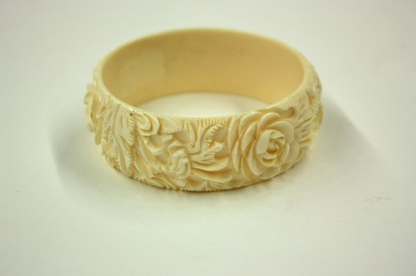 Flower Carved Ivory Bangle Bracelet: Carved ivory bangle bracelet, the exterior carved and undercut with flowering rosette sprigs in high relief, outer dia:3.2''dia; inner dia: 2.5''dia