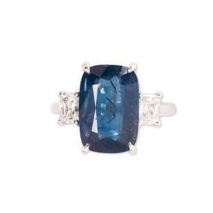 A Burma no-heat sapphire and diamond ring: A Burma no-heat sapphire and diamond ringthe cushion-mixed cut sapphire, weighing 7.12 carats, four-prong set between a pair of scissor-cut diamonds, each weighing 0.50 carat; accompanied by AGL