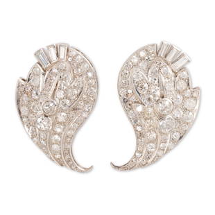 A pair of diamond ear clips: A pair of diamond ear clipseach an upswept spray of old mine, single or baguette-cut diamonds, in millegrained platinum, with fourteen karat white gold fittings; estimated total diamond weight