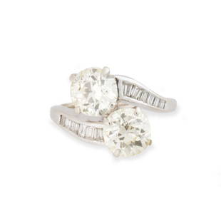 A diamond and fourteen karat white gold ring: A diamond and fourteen karat white gold ringof "moi et toi" design, featuring two old-European cut diamonds, each weighing approximately 1.60 carats or 1.70 carats, between channel-set baguette-cut