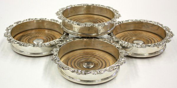 sterling silver wine coasters: Set of four sterling silver wine coasters having turned wood bases, center monogram, and embossed s-scroll rim, hallmarked city of London, 1792, George III, Henry Chawner maker's mark registered 1786