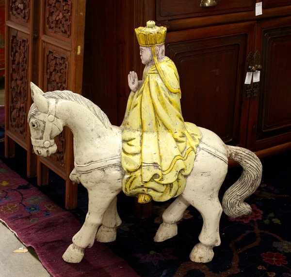 Buddhist Figure of Monk on Horse: Chinese pigment decorated wood figure of a Buddhist monk, probably Xuanzang, wearing monastic robes and a monk's cap and seated on a white horse, 26''l