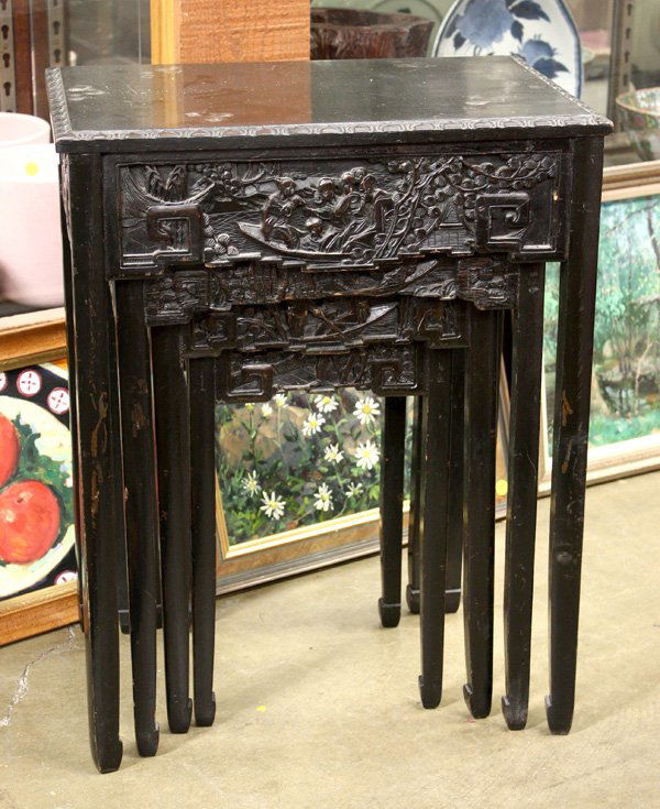 Carved Chinese Wood Nesting Table: Set of four Chinese carved wood nesting tables, of graduated size, each with a rectangular top framed by a lotus patterned edge, the side apron depicting figural scenes in relief, the slender supports