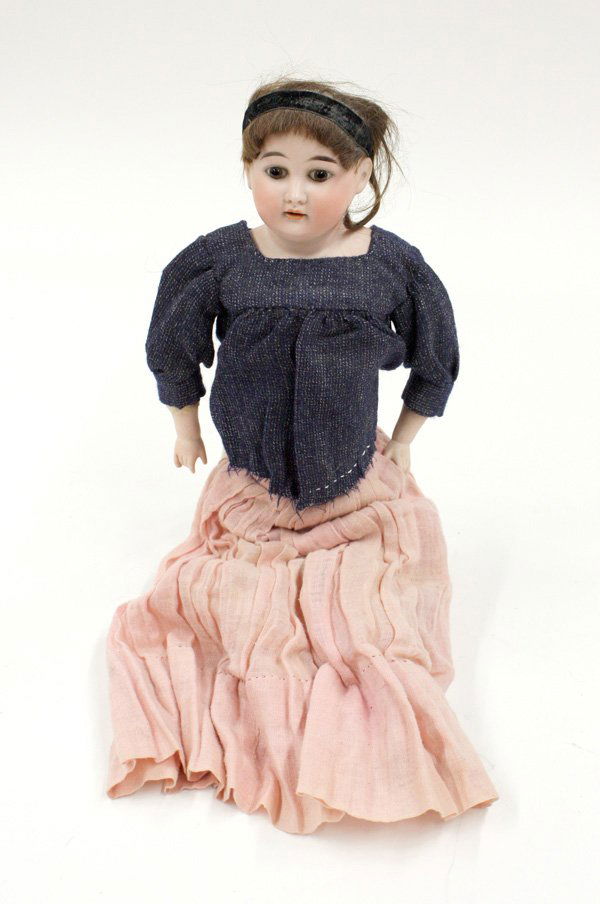 German antique bisque shoulder plate doll: German antique bisque shoulder plate doll having a hand painted face set with brown stationary eyes and an open mouth showing teeth, jointed to a kid body with bisque arms and hands and cloth legs, ap