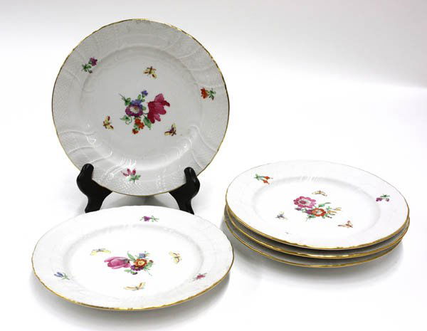 KPM polychrome decorated porcelain plates: (lot of 5) KPM polychrome decorated porcelain plates, each with a gilt border around basketweave pattern on white ground, having a painted floral and butterfly motif at center, signed with red K P M m