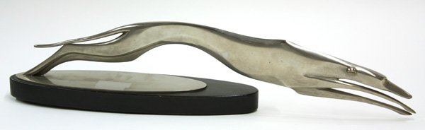 Art Deco style white metal greyhound: Art Deco style white metal figure of a racing greyhound, depicted in full stride, and raised on an oval wood base 19.5''l