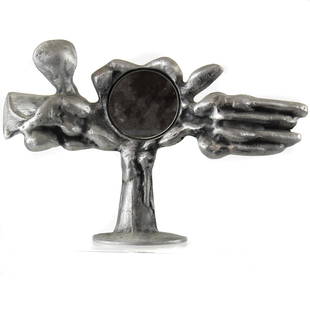 A Donald Drumm (b. 1935) aluminum mirror: A Donald Drumm (b. 1935) aluminum mirror, having a circular looking glass surrounding an organic frame, signed on reverse, 11"h, together with a wire sculpture of a hand, signed indistinctly, 11.5"h