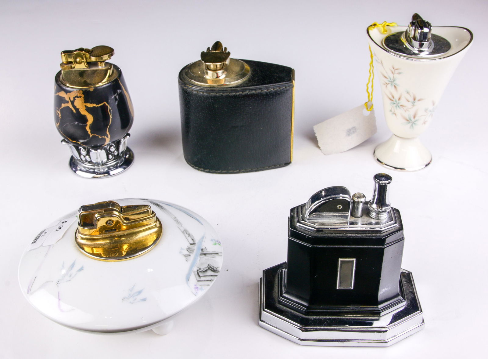 (5) Vintage lighters: a Mark Cross Italy leather; (2): (lot of 5) Vintage lighters: a Mark Cross Italy leather mounted ligher as well as (2) Ronson; a Lenox and a Rosenthal china cased lighters, the tallest 4"h