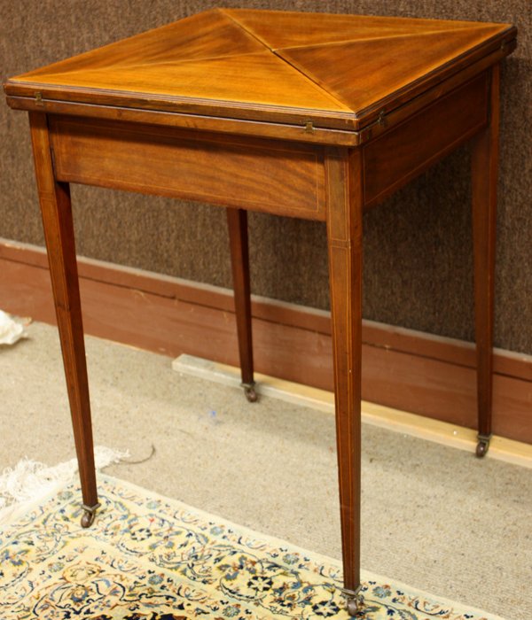 French mahogany inlaid folding game table: French mahogany inlaid folding game table, the string inlaid revolving top having quadrant folding leaves opening to reveal a felt playing surface, above a single drawer and raised on square tapering 