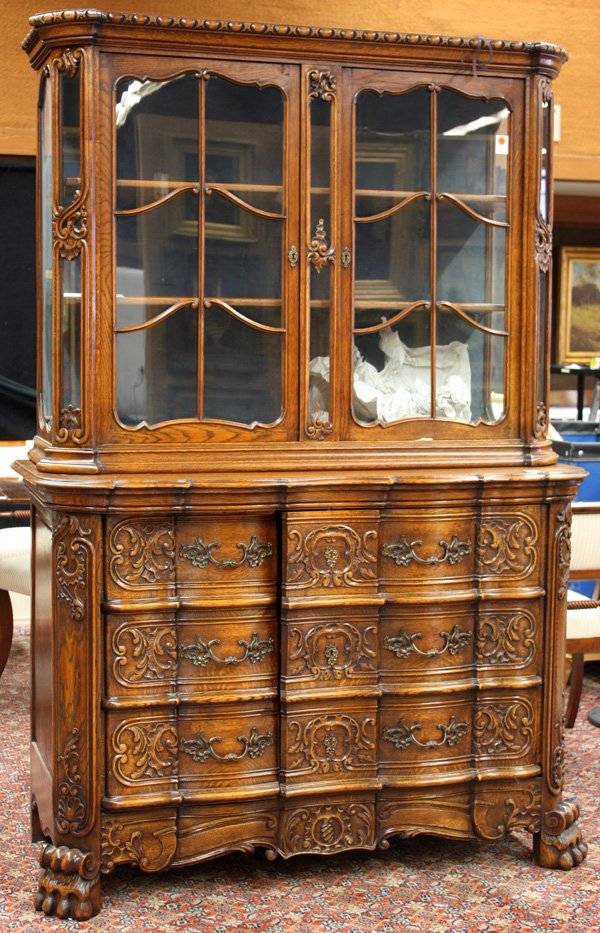 Continental heavily carved oak buffet: Late nineteenth century Continental heavily carved oak buffet, the vitrine top with original rolled glass panels, the lower case having false drawer covered doors, and raised on carved paw feet 79.5''
