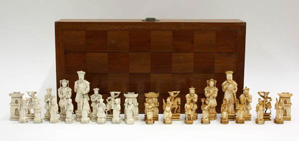 Chinese Ivory Chess Set: Chinese ivory chess set with wood board/case, 20th century, consisting of 16 carved ivory pieces of natural hue and the remaining 16 of tinted coloration, fashioned with the Eight Daoist Immortals and