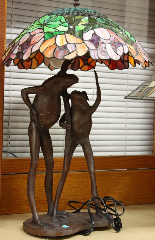 Stained glass lamp: Bronze figural lamp base depicting two standing frogs topped with a stained and leaded glass shade 26''h