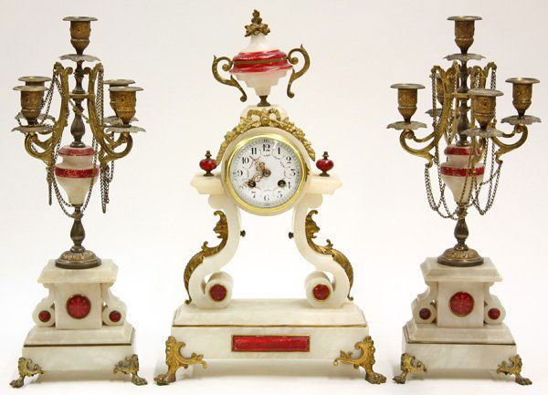 French clock and garniture set: (lot of 3) French clock and garniture set, executed in white marble with rose accents and gilt brass mounts, the clock with urn form finial surmounted with floral decoration and a white enamel dial wi