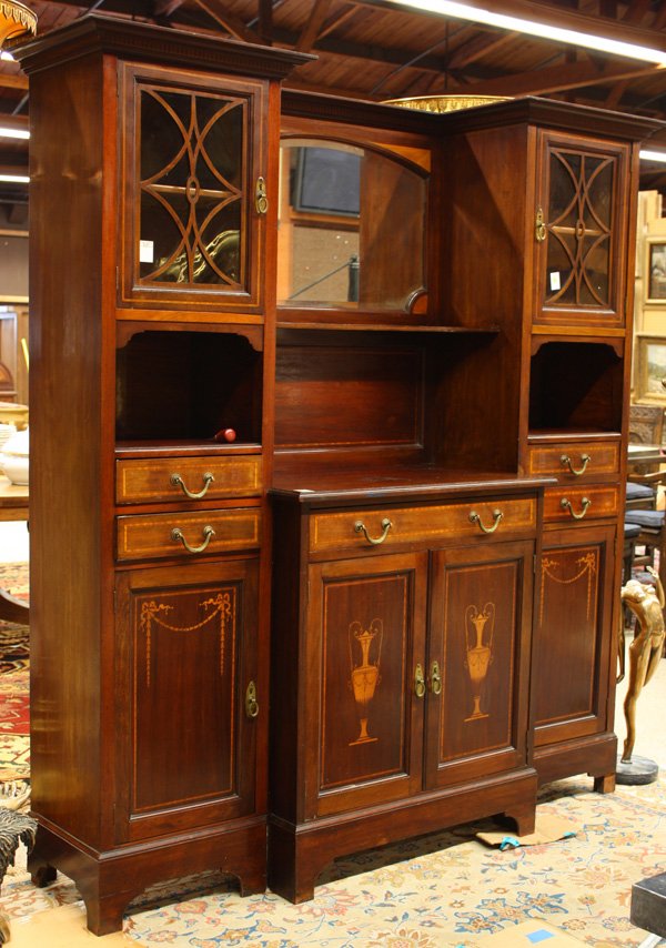 French inlaid mirror back credenza: French inlaid mirror back buffet circa 1910, the bevelled mirror framed by fan inlay above a breakfront case with handled urn marquetry, and flanked by vitrines having bell flower inlay and raised on