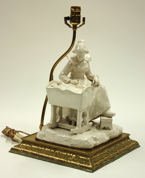 Figural ceramic and mixed metal lamp: Figural ceramic and brass lamp, depicting a mother and her sleeping child, and raised on a ogee brass base 17.5''h (crazing)