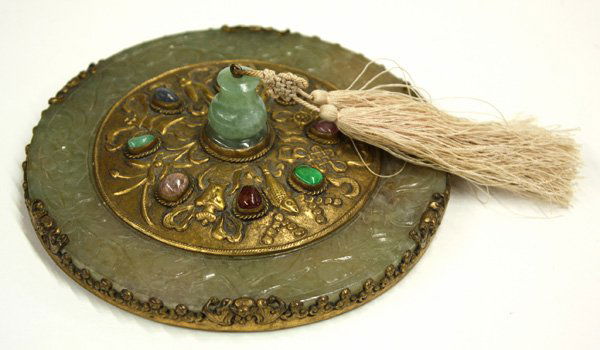 Chinese Jade and Gilt Metal Hand Mirror: Chinese jade and gilt metal circular hand mirror, backed by celadon-hued jade plaque carved with fruiting peach sprays overlaid by a smaller circular gilt metal plate with a repousse design of the ''E