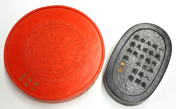 Chinese Cinnabar/Ink Cakes: (lot of 2) Chinese molded cinnabar/ink cakes: the first a circular disk of brilliant red hue with a stylized mythical beast supporting a lotus blossom, reversed by a flaming wheel framing a Tibetan in