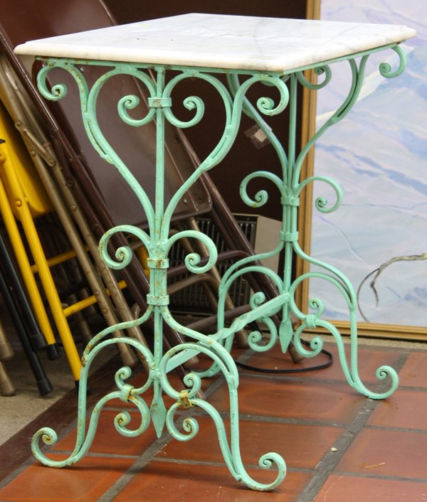 Marble top table on wrought iron base: Marble top table, the rectangular top above a polychrome wrought iron base 28.5''h x 30''w x 19''d