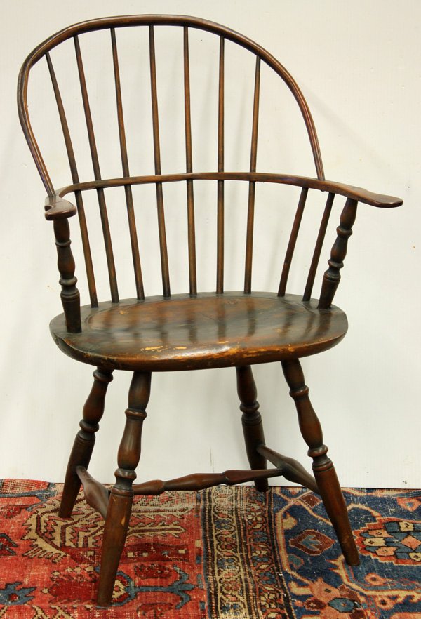 American sack back windsor arm chair: American sack back windsor arm chair, the eleven turned spindles terminating at the oval seat framed by incising and raised on splayed baluster turned legs joined with an H stretcher, having traces of