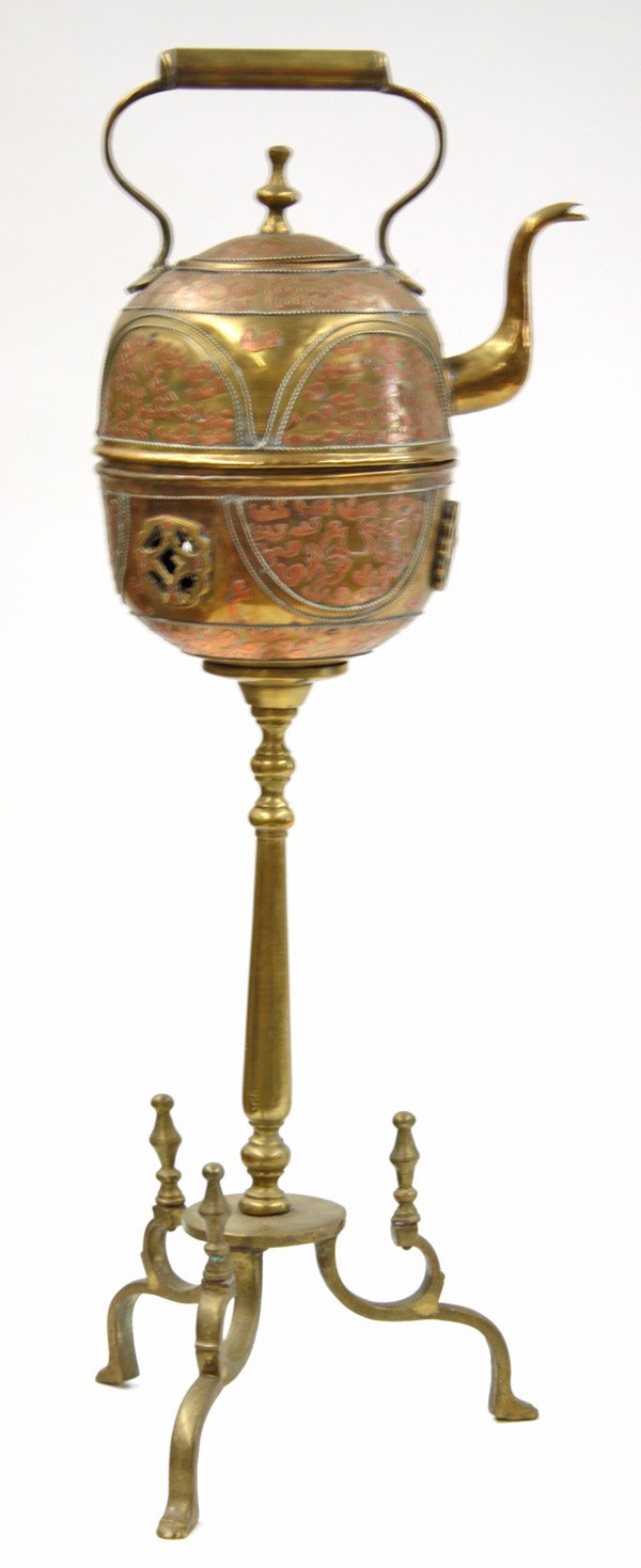 Copper and brass kettle: Asian inspired copper and brass kettle fitted onto a tripod pedestal brazier having copper relief Arabic inscriptions, 32''h