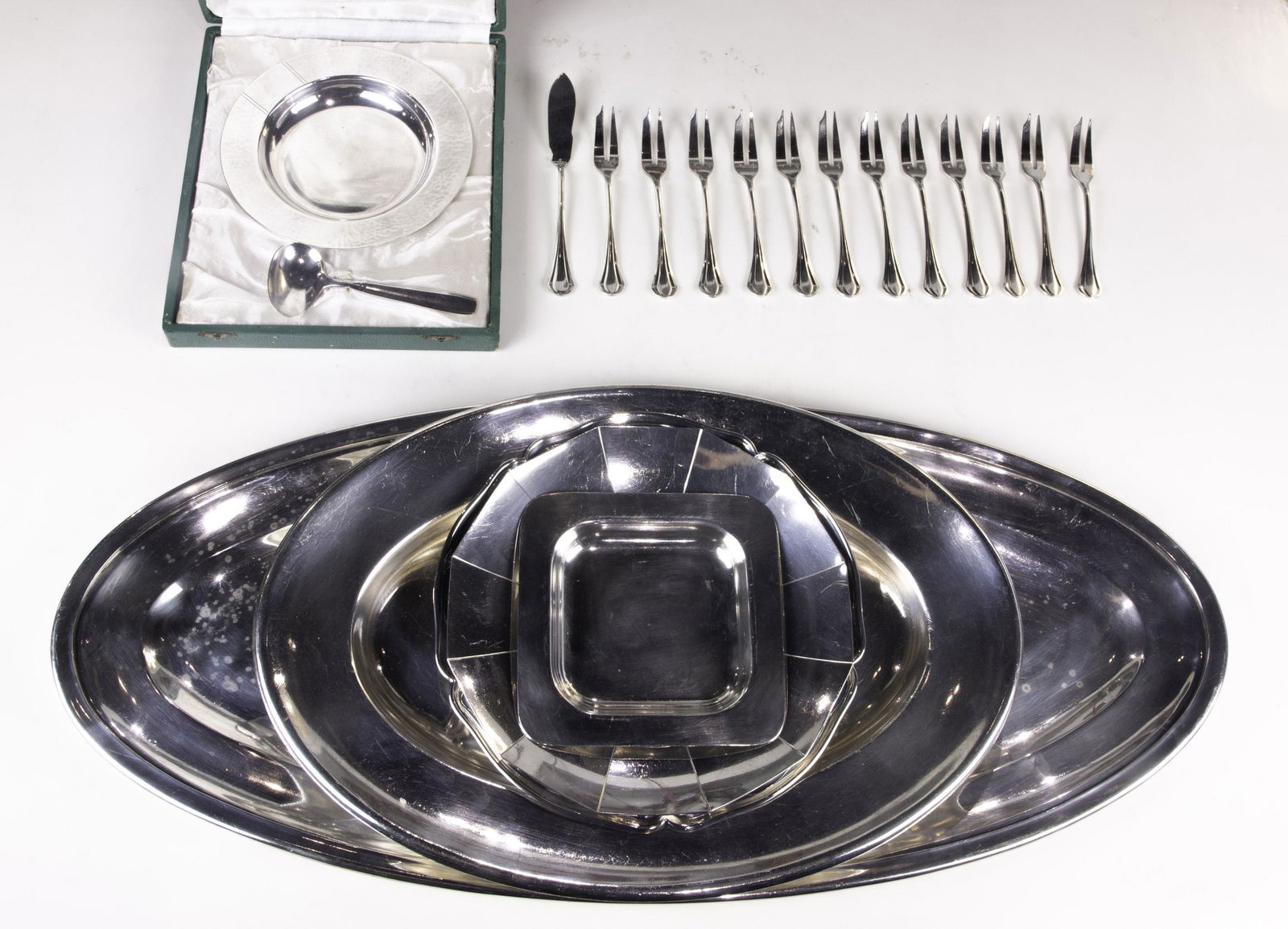 (lot of 19) Associated silver plate table objects: (lot of 19) Associated silver plate table objects, including a cased Christolfe set, French Ercuiz Plate forks and knives, (2) oval trays, (2) round trays, together with a small square tray, largest 2