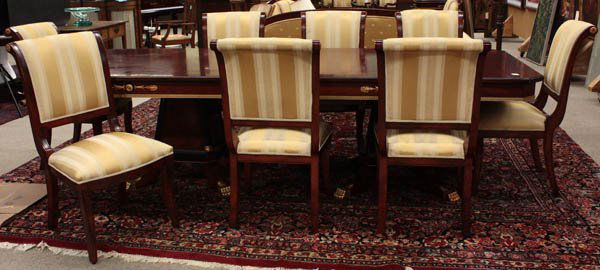 Neoclassical style dining table and eight chairs: (lot of 9) Neoclassical style dining table and eight chairs, the table having a band inlaid top above an apron having gilt medallions, rising on double pedestals with fluted corners and rising on outs