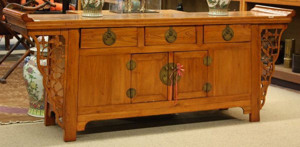 Chinese Elm Wood Coffer: Chinese carved elm wood coffer, topped with a long rectangular plank set with swallow-tail ends, fronted by a row of three drawers above hinged double doors, all bracketed by floral pierced spandrels