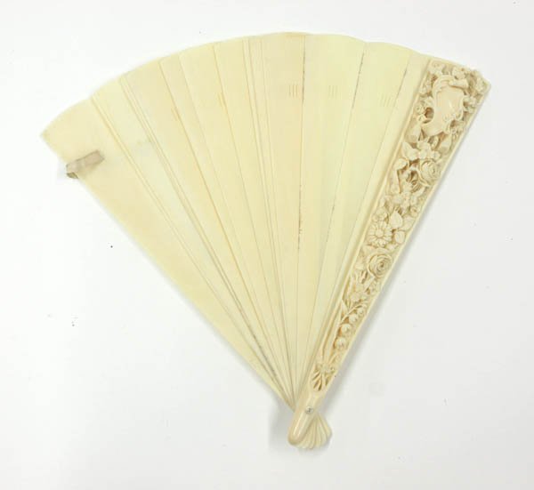 Carved Ivory Fan, 19th Century: Ivory fan, 19th century, the top of the front guard well carved and undercut with an escutcheon surrounded by various types of blossoming sprays continuing down the length but stopping short of the pi