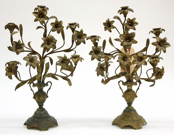 Pair of gilt metal floral candelabra: Pair of gilt metal floral candelabra, the five lights set between blooming lillies in an urn form vase and rising on a footed base 19''h x 14''w (lacking 2 bobeches)