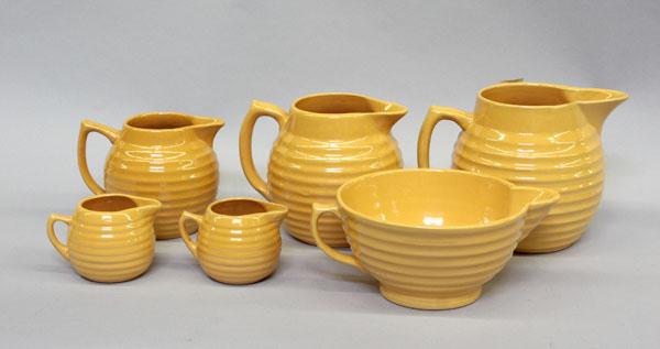 Bauer of California graduated pitchers: (lot of 6) Bauer of California Monterey Ringware graduated pitchers,unsigned, largest 7.25''h x 10''w, together with a batter bowl 4.5''h x 10.75'', both executed in canary yellow, batter bowl with im