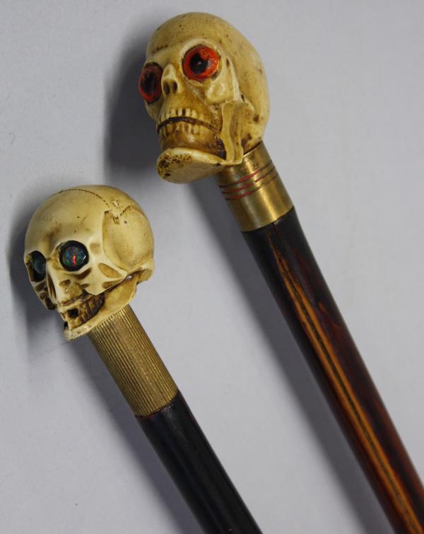 Skull capped walking stick: (lot of 2) Composite skull capped walking sticks, each having a bamboo shaft concealing a hidden sword, both with the original brass tips 36''h