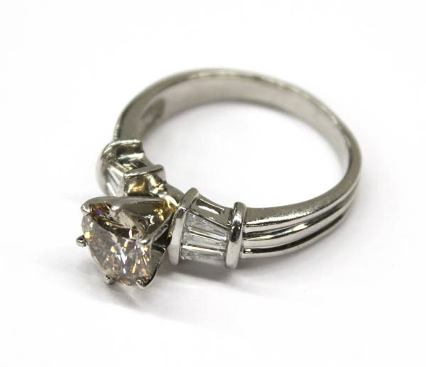 Diamond ring platinum: Diamond solitaire ring; mounted in platinum, center set with (1) champagne colored round diamond weighing 1.80 cts, accented by (6) baguette cut diamonds weighing 0.50 ct. Total ring weight 10.5 grams