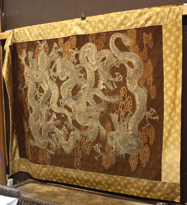 Japanese Textile Panel, Dragon: Japanese large textile panel, Meiji period, finely embroidered with seven dynamic dragons writhing amidst stylized clouds on a couched spiral ground of dark brown hue, with brocade silk mountings, rev